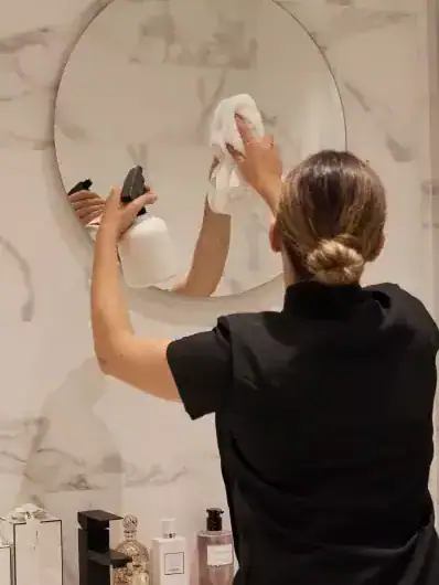 Employé de ménage Maison Helya nettoyant la salle de bain de ses clients