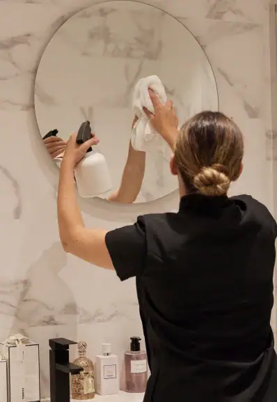 Employé de ménage Maison Helya nettoyant la salle de bain de ses clients