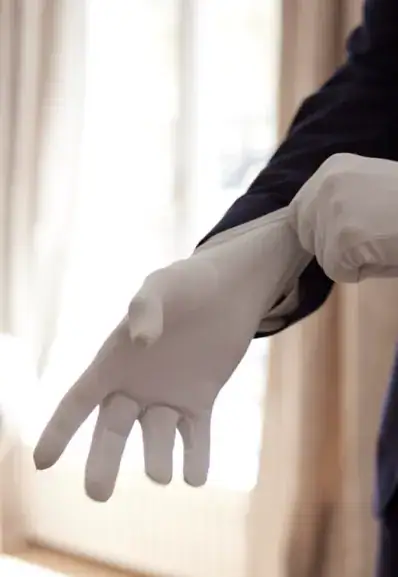 Un majordome Maison Helya ajuste sa paire de gants